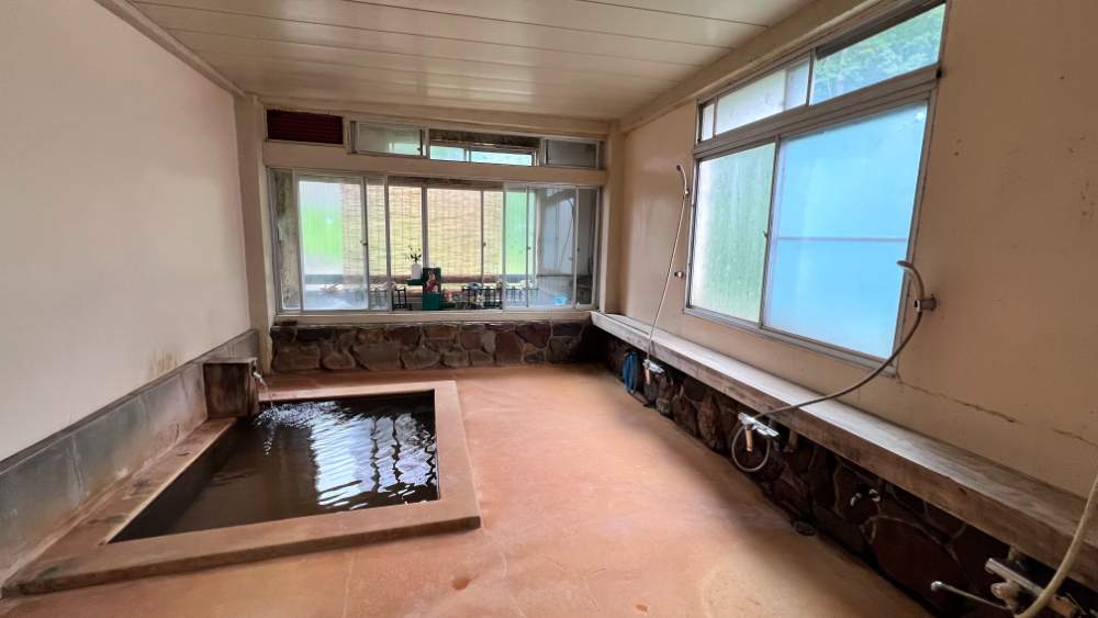 Large onsen bath filled with natural hotspring water.